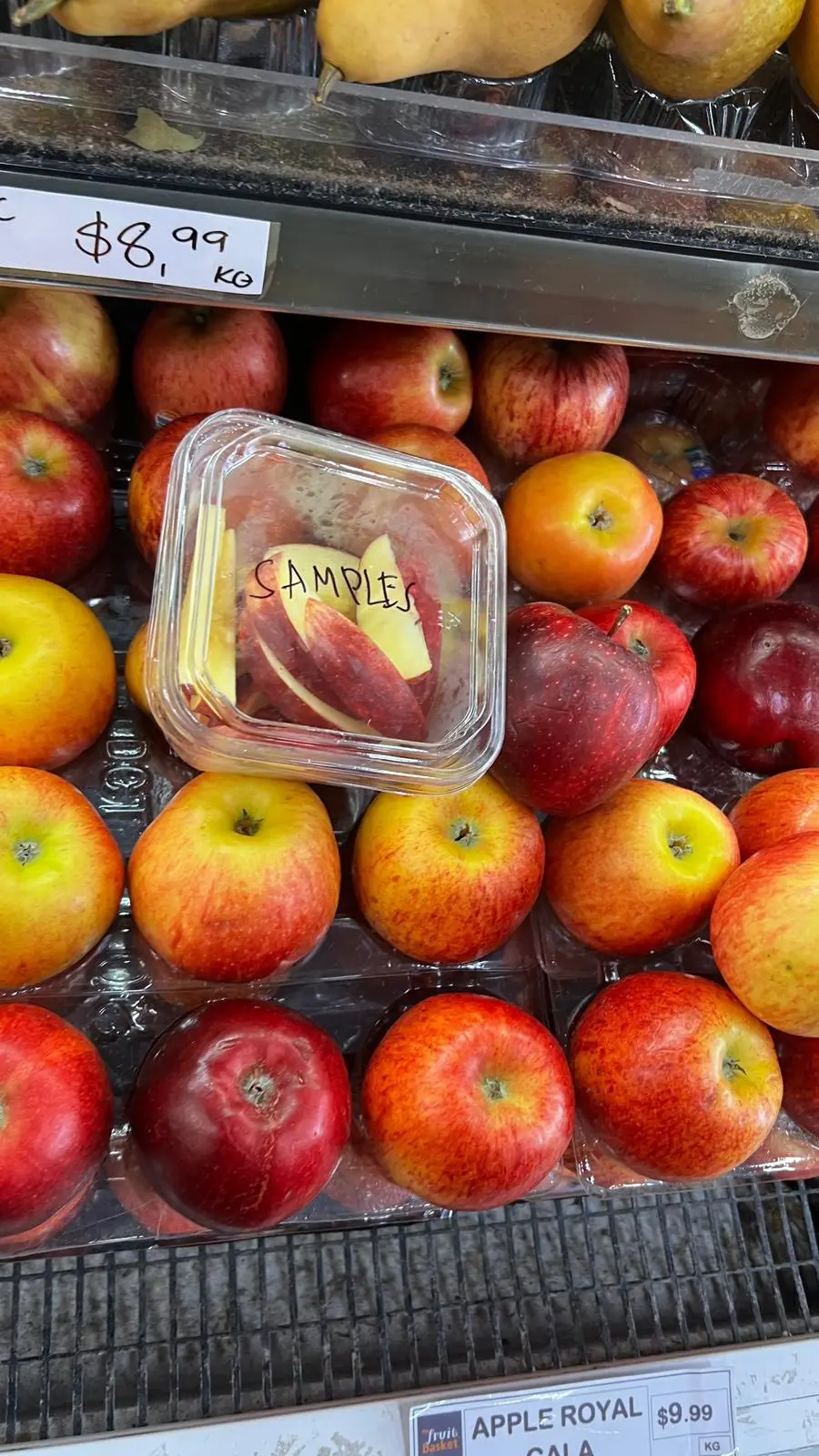 Apples on the shop display with a tray of cut samples