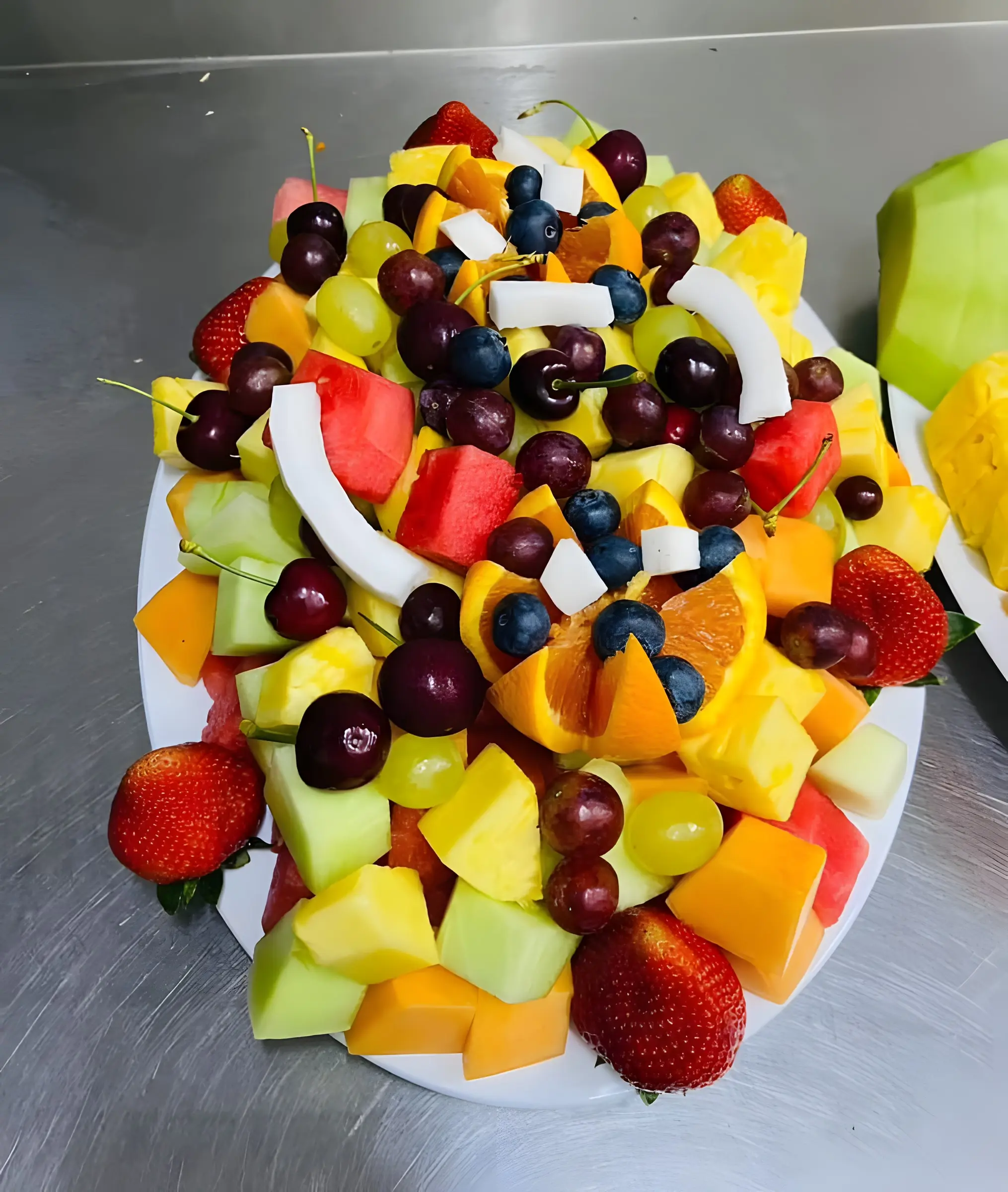 Colourful fruit kebabs on a serving platter with strawberries, melon and grapes