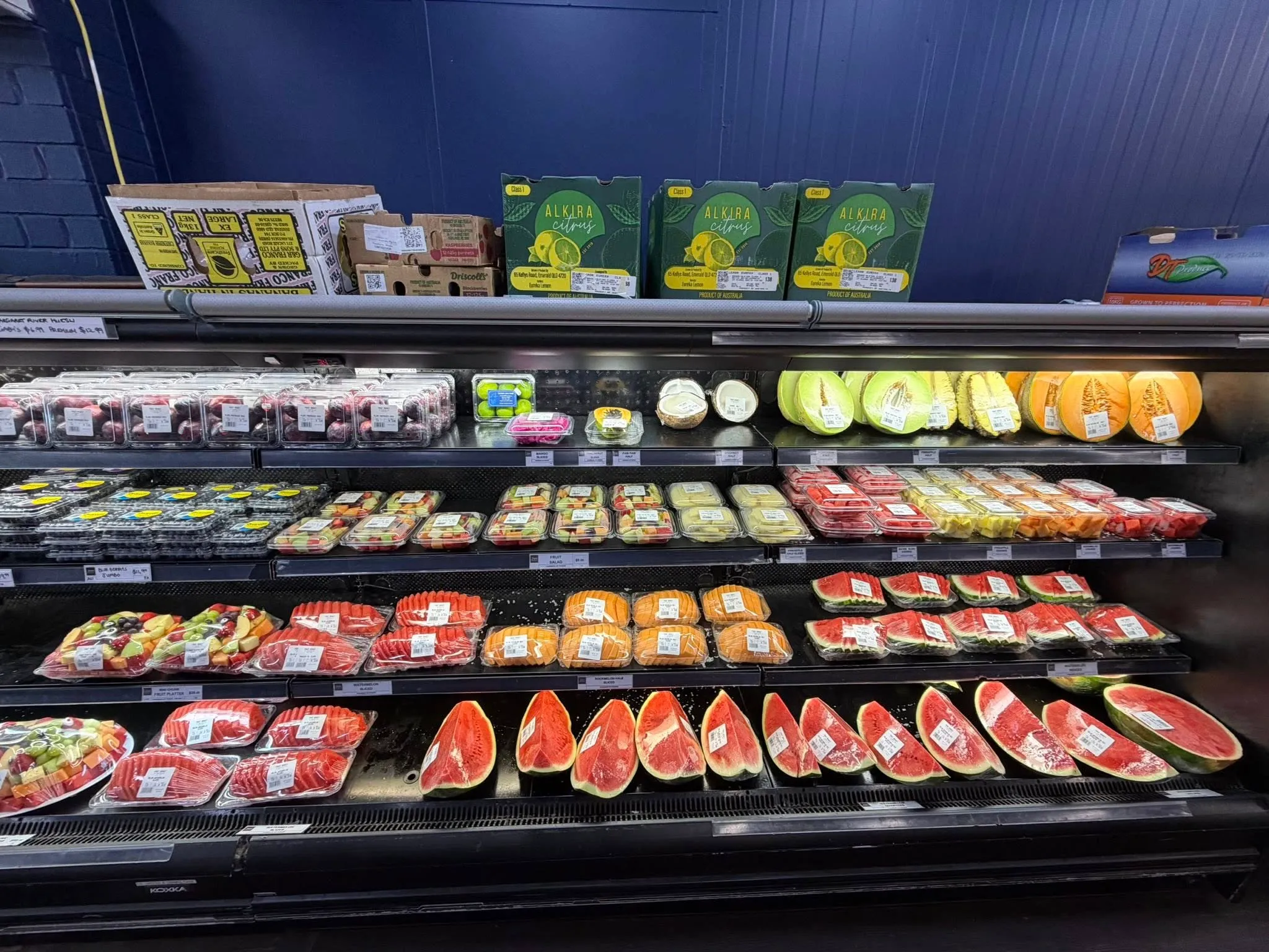 Tiered display of green pears, red apples and orange citrus