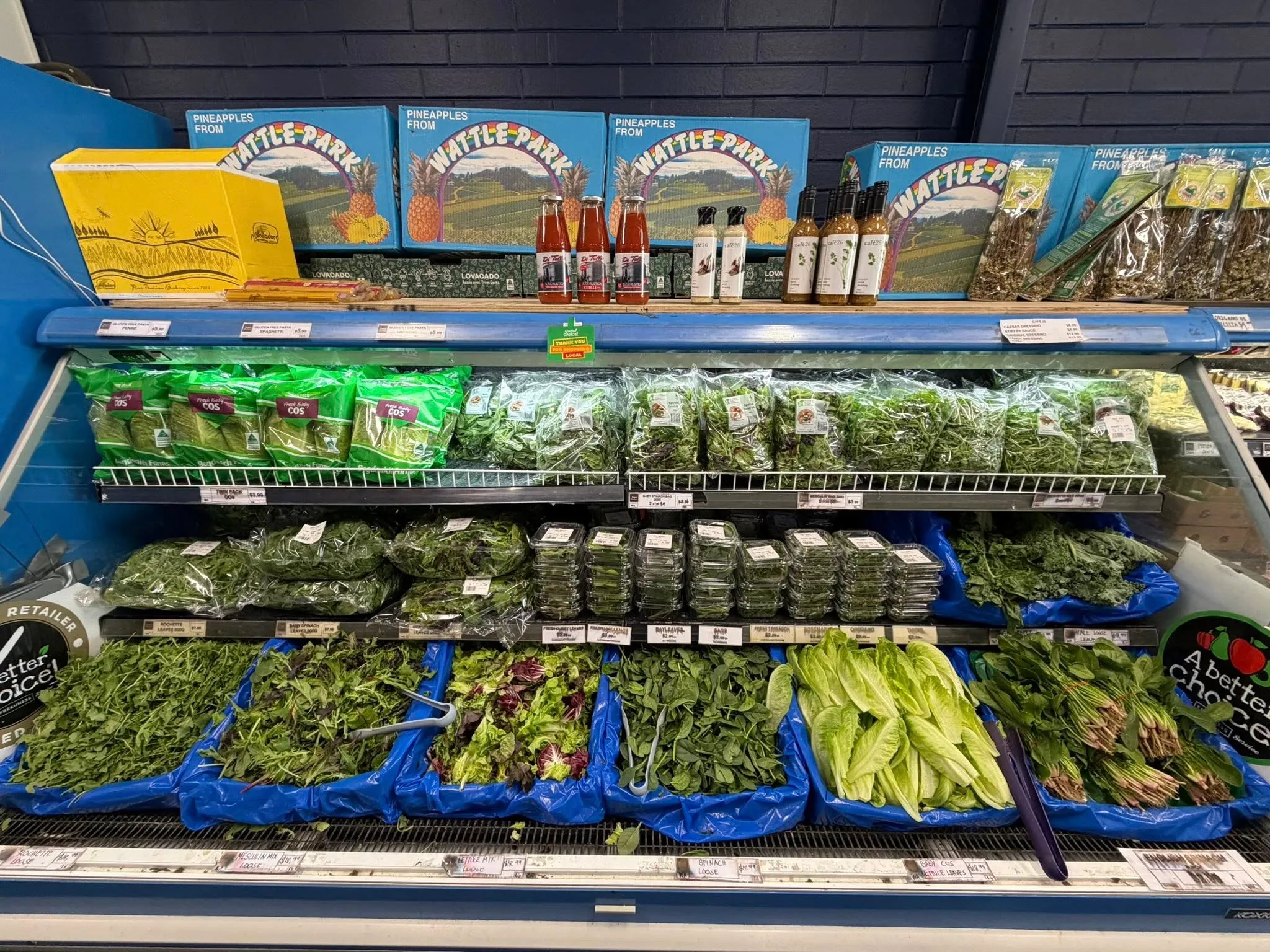 Refrigerated case with fresh leafy greens, herbs and lettuce packages