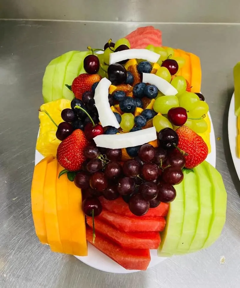 Mixed fruit salad tray ready for serving with melon, orange and berries